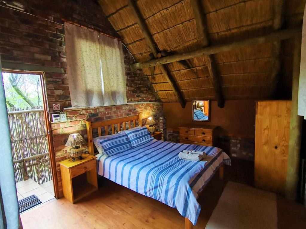 1 dormitorio con 1 cama en una habitación con ventana en Otters' Haunt Eco Retreat, en Parys