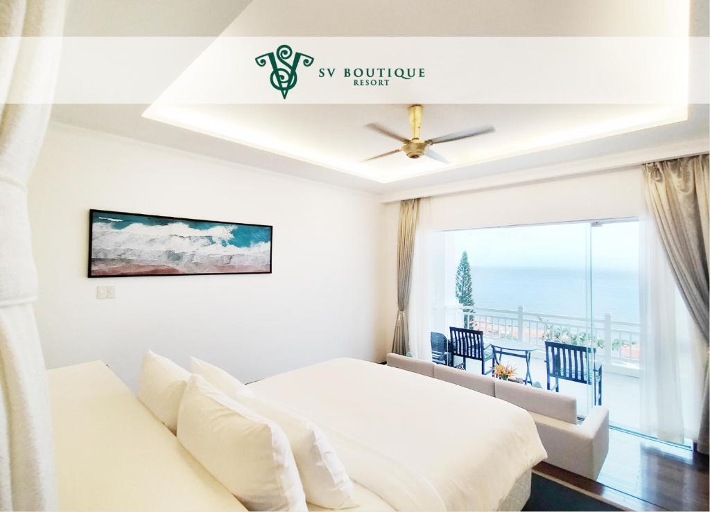 a white bedroom with a bed and a window at SV Boutique Resort in Vung Tau