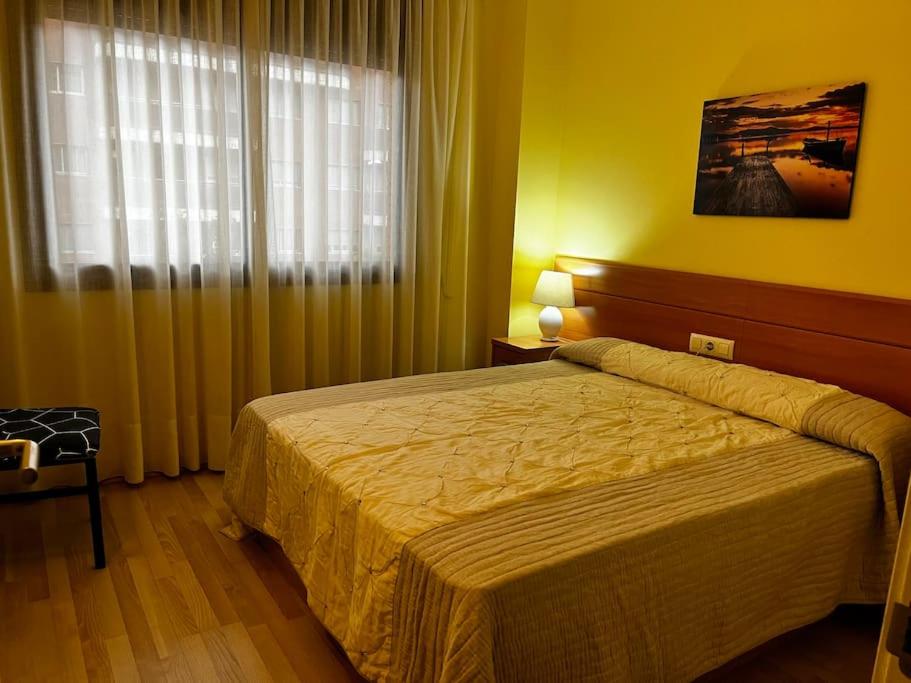 1 dormitorio con 1 cama y una ventana con cortinas en Hermoso apartamento con piscina a 300m de la playa, en Lloret de Mar