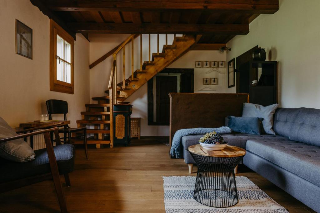 a living room with a blue couch and a table at Kellerstöckl Berg 106 in Strem