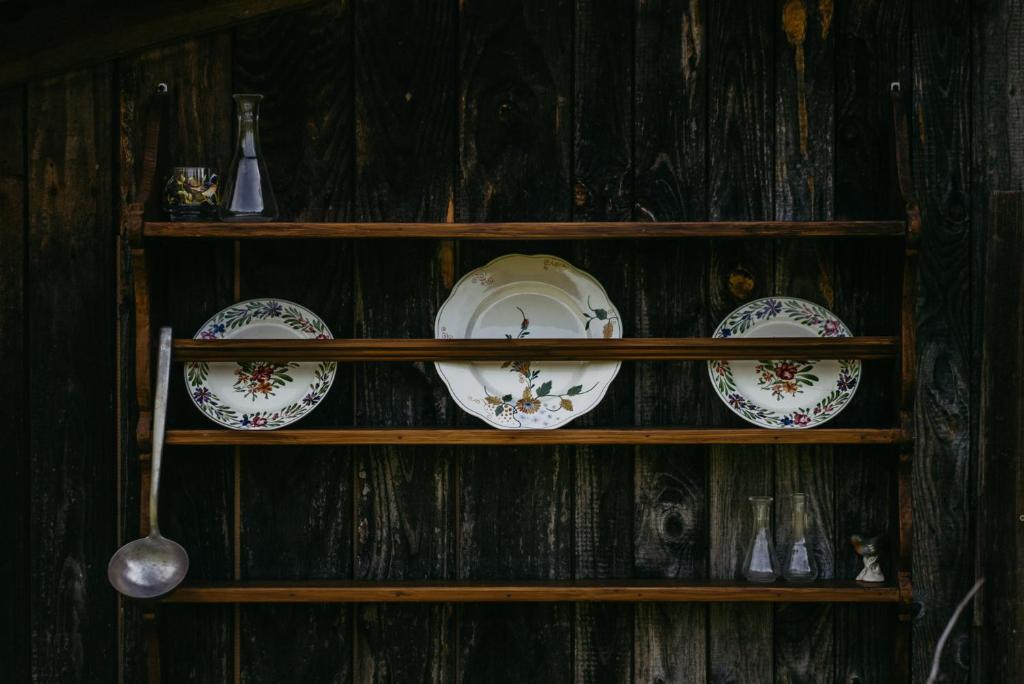 a shelf with plates andoons on a wooden wall at Kellerstöckl Berg 106 in Strem