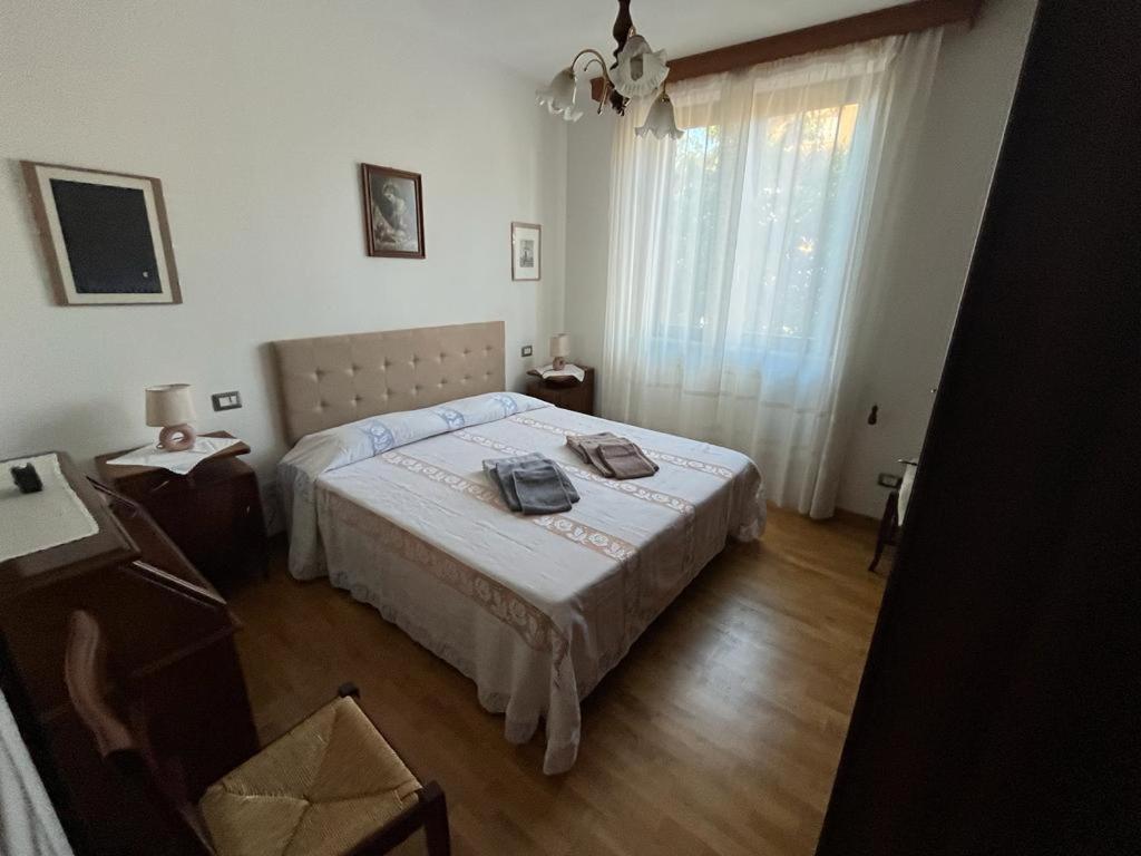 a bedroom with a large bed and a window at Casa Gianfranco in Gubbio