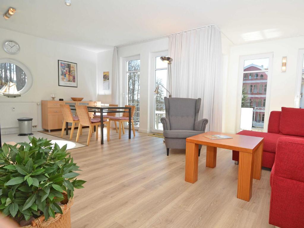 sala de estar con sofá rojo y mesa en Villa am Park - Apt. 02 Düne, en Ostseebad Sellin