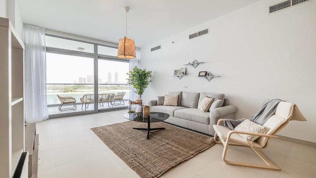 uma sala de estar com um sofá e uma mesa em Hashtag Holiday Home - Luxury 2BDR Apartment on The Palm Azure Residences em Dubai