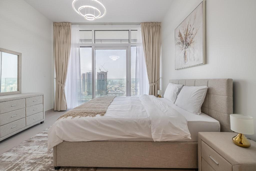 a bedroom with a large bed and a large window at Close To Metro with Frame View in Dubai