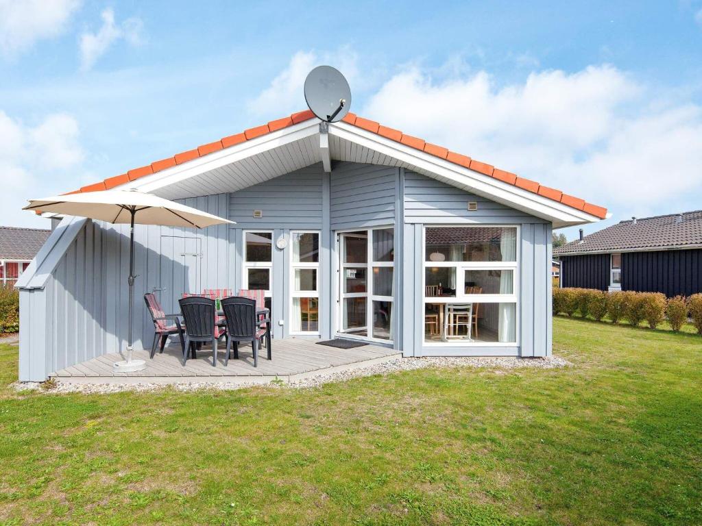 a shed with a table and chairs on a deck at 6 person holiday home in GROEMITZ in Grömitz