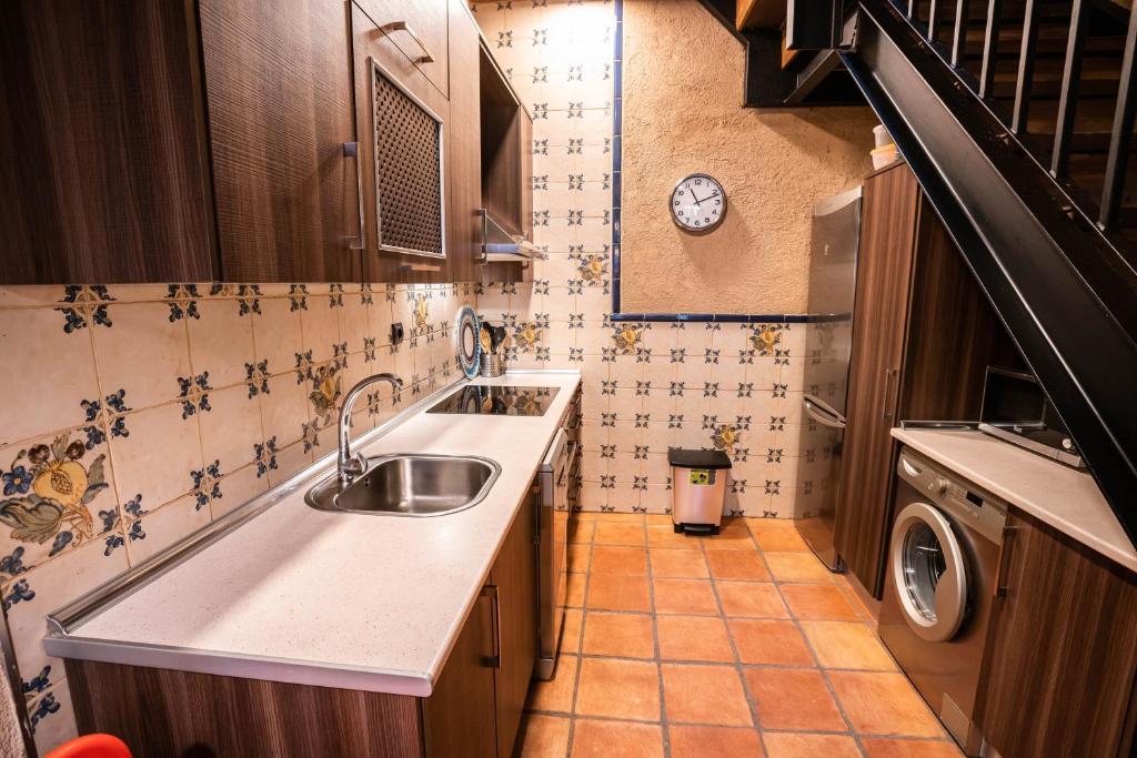 a small kitchen with a sink and a washing machine at Sierra de Gata EL CORRAL DE LA HIGUERA in Torre de Don Miguel