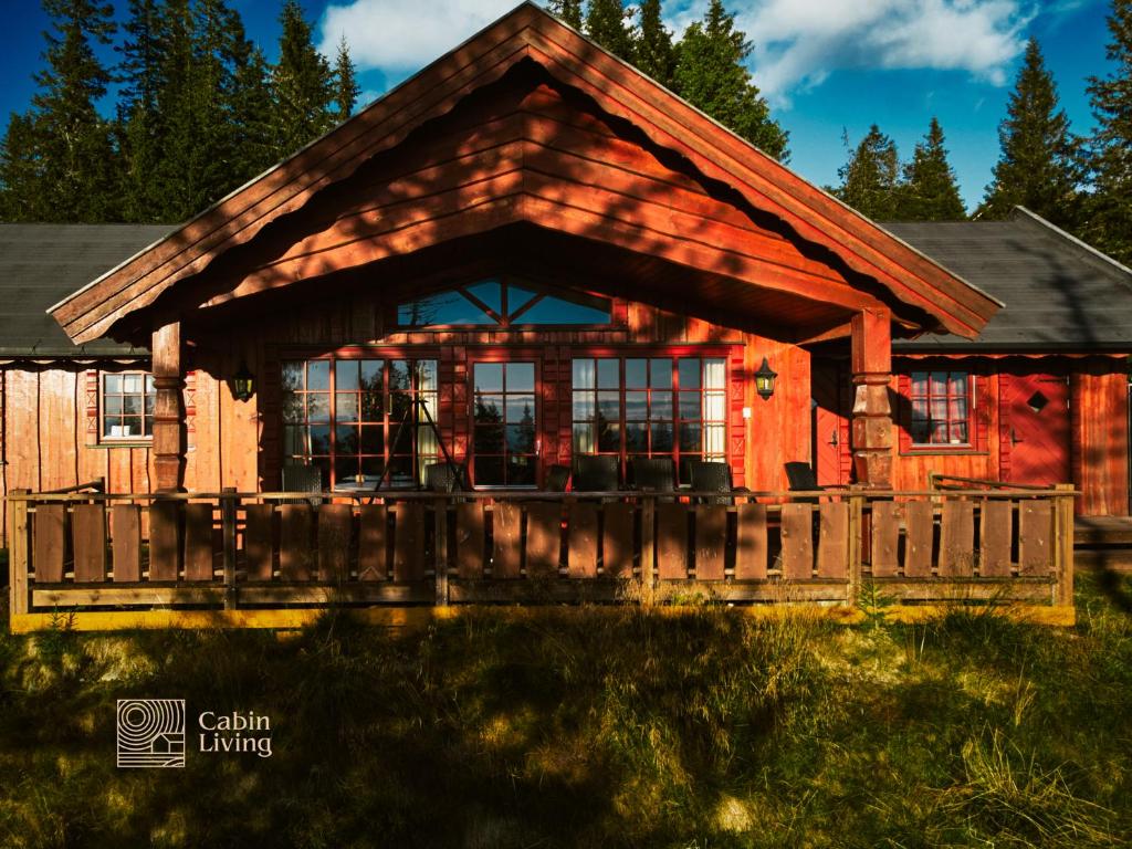 a log cabin with a fence in front of it at Large Cottage 2 Baths and Sauna in Sjusjøen in Lillehammer