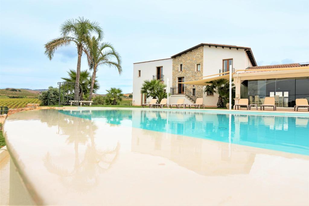 a swimming pool in front of a house at La Corte del Sole in Calatafimi
