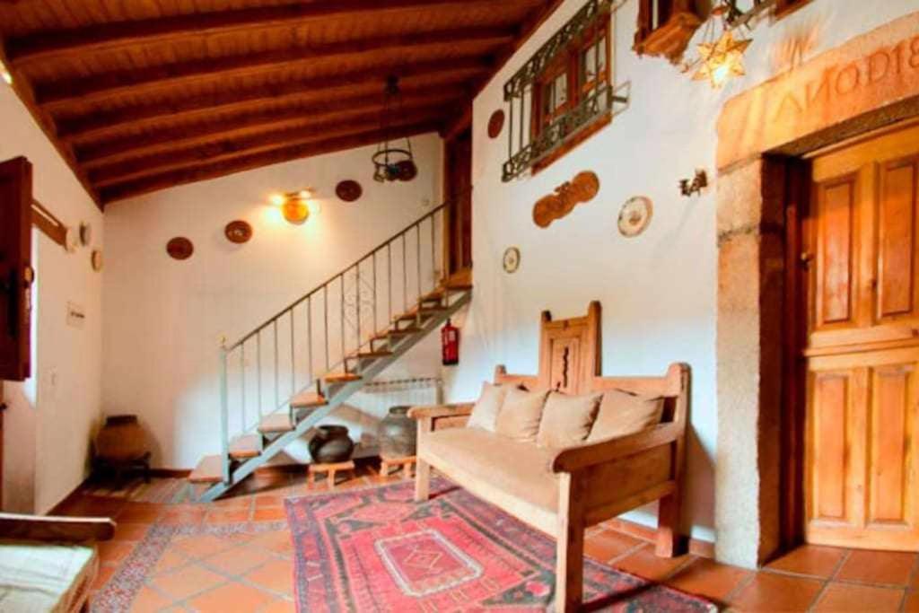 a living room with a couch and a staircase at Tía Clotilde es una casa grande ideal para familias y grupos de amigos in Cabezas Bajas