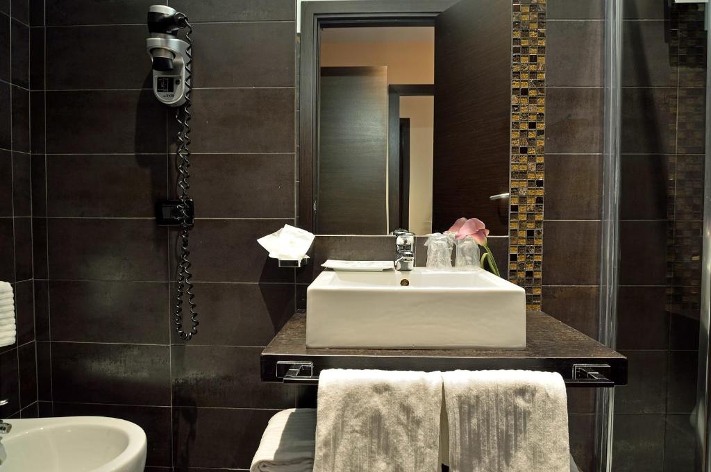 a bathroom with a sink and a mirror at Catone District Hotel in Rome