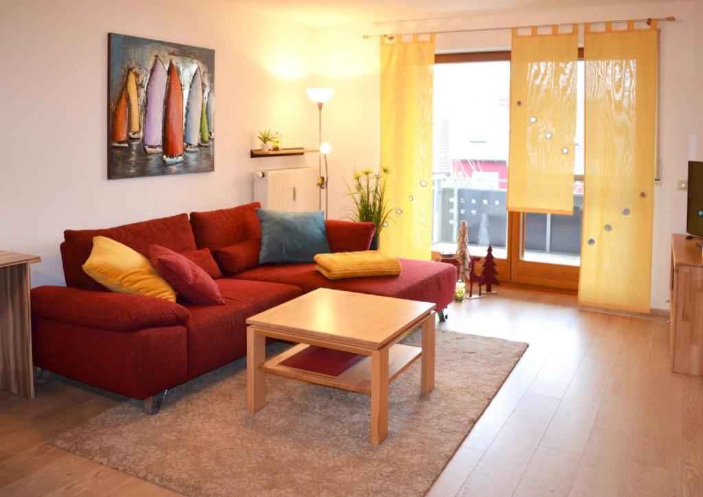 a living room with a red couch and a table at Ferienwohnung Nebenan in Ebern