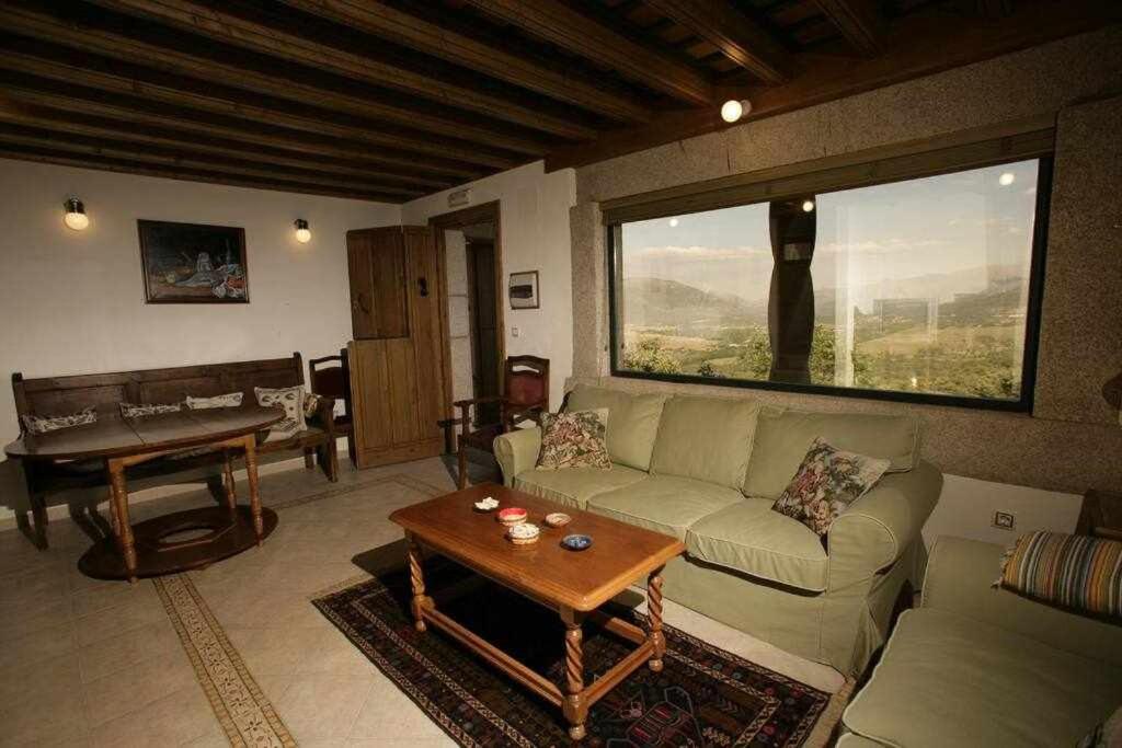 uma sala de estar com um sofá e uma mesa em Apartamento Rural El Labrador es un cómodo y acogedor apartamento em Cabezas Bajas