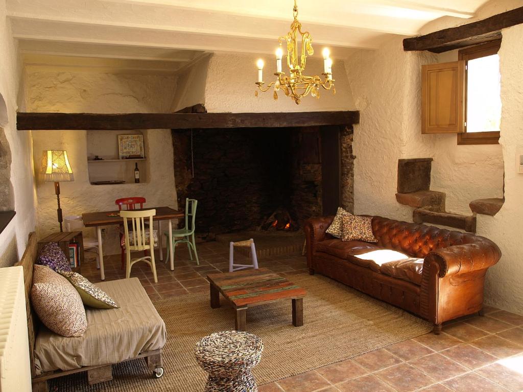 sala de estar con sofá y chimenea en Ca l'Agnès, en Montseny