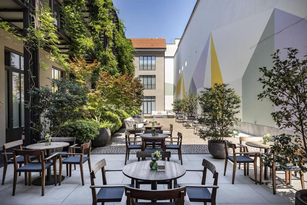 un patio al aire libre con mesas y sillas en Savona 18 Suites en Milán