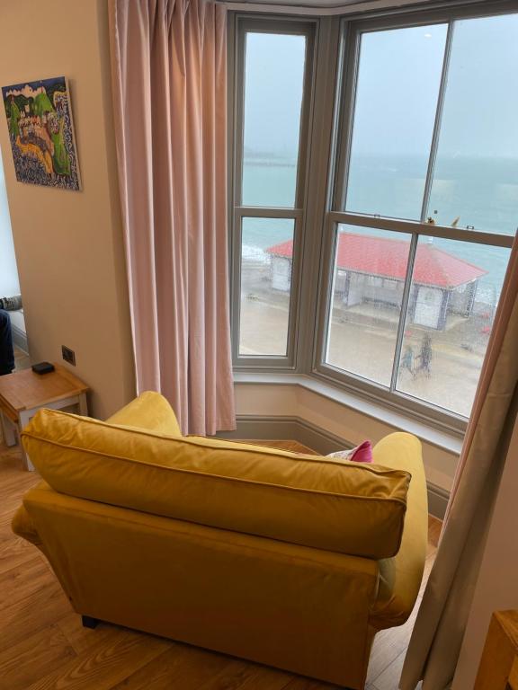 a living room with a couch in front of a window at Sea View Apartment - Sleeps 2 in Aberystwyth