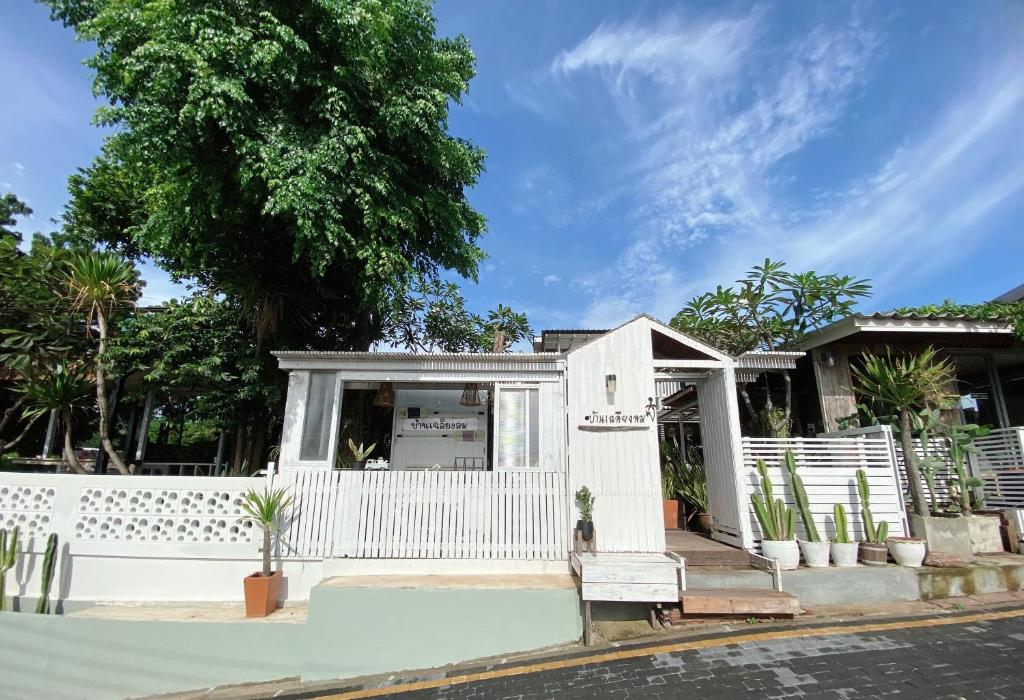 a white house with a white fence and trees at Chalianglom Resort Kohlarn in Ko Larn