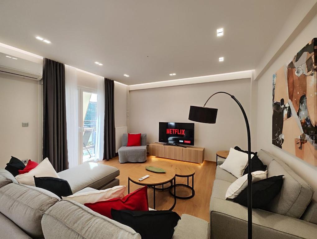 ein Wohnzimmer mit 2 Sofas und einem TV in der Unterkunft Etolou C2 - by Verde Apartments in Athen