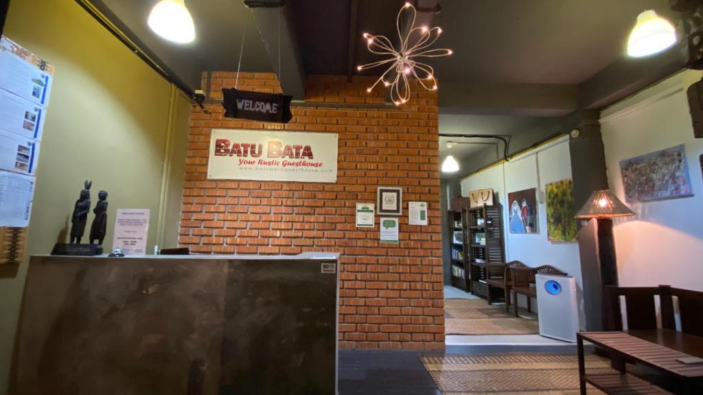 a restaurant with a brick wall and a sign on the wall at Batu Bata Guesthouse in Kuching