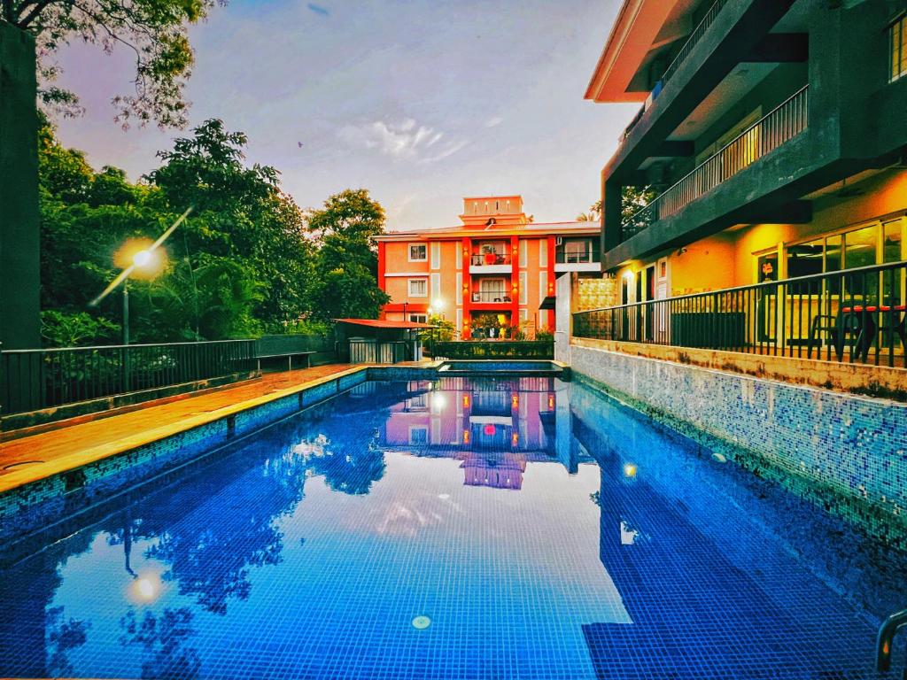a swimming pool in front of a building at 2BHK Stunning Apartment with Pool in Vagator