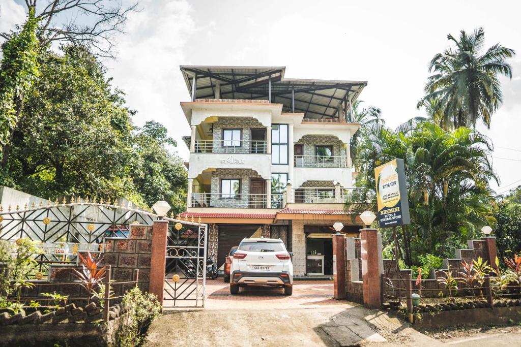 a car parked in front of a building at Dhanashree Riverview Hotel in Corgao