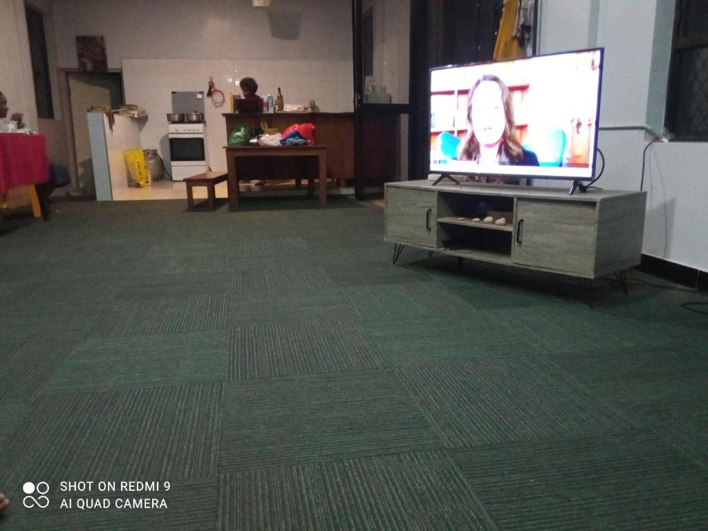 sala de estar con TV de pantalla plana en un centro de entretenimiento en Marine Apartments en Honiara