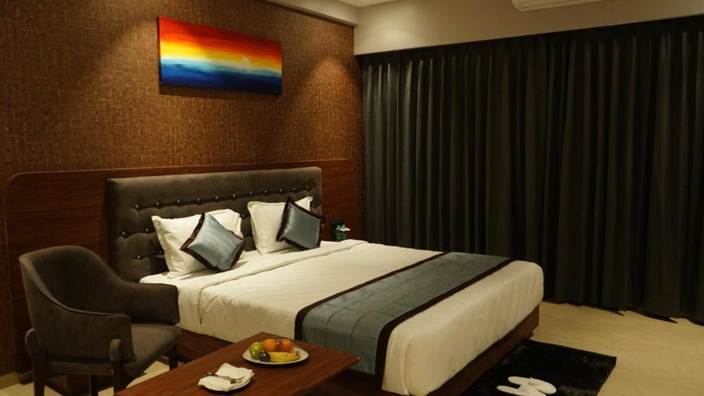 a hotel room with a large bed and a table at Alaukik Hotel in Shirdi