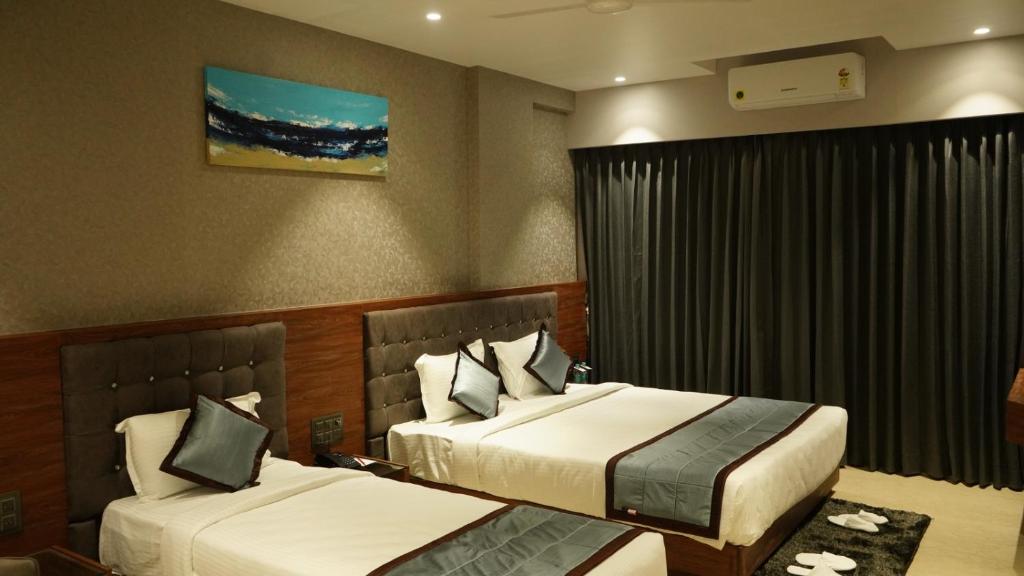 Postel nebo postele na pokoji v ubytování Alaukik Hotel