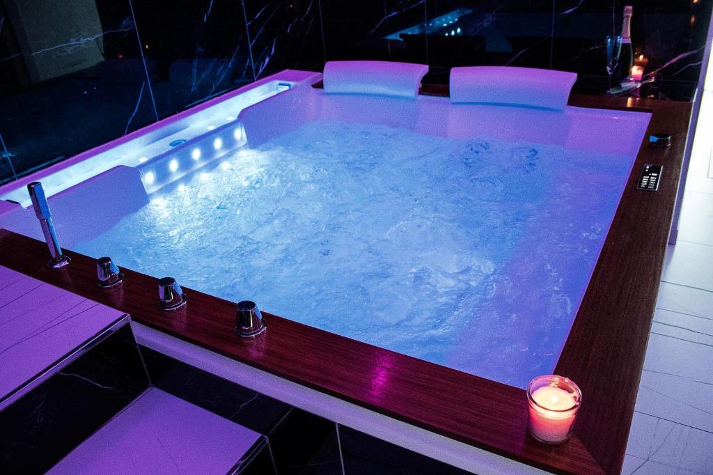 a large jacuzzi tub with a candle in it at Suite Élite in Catania
