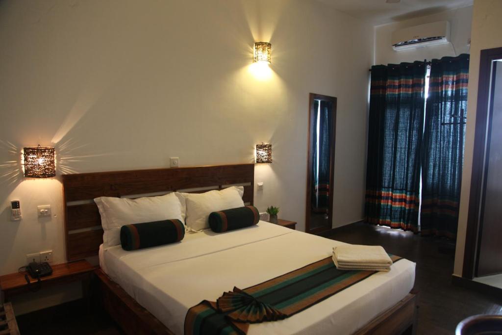 a bedroom with a large white bed with two lamps at Bay Vista in Arugam Bay