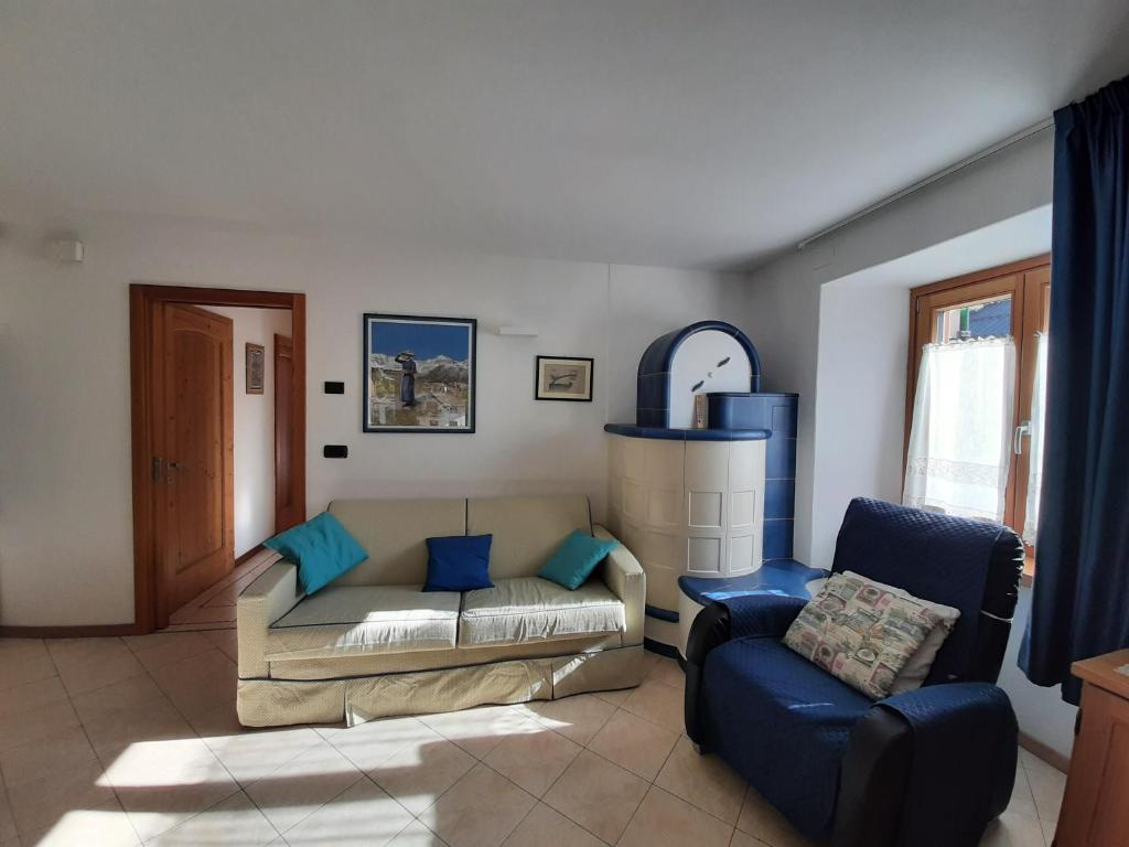 a living room with a couch and a chair at NUOVISSIMO BILOCALE PALAZZINA VENERI in Cogolo