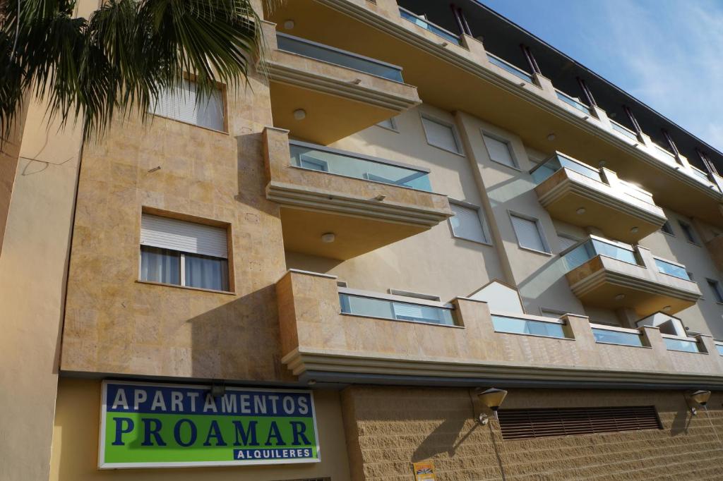 un bâtiment avec un panneau devant lui dans l'établissement Apartamentos Proamar, à Torre del Mar