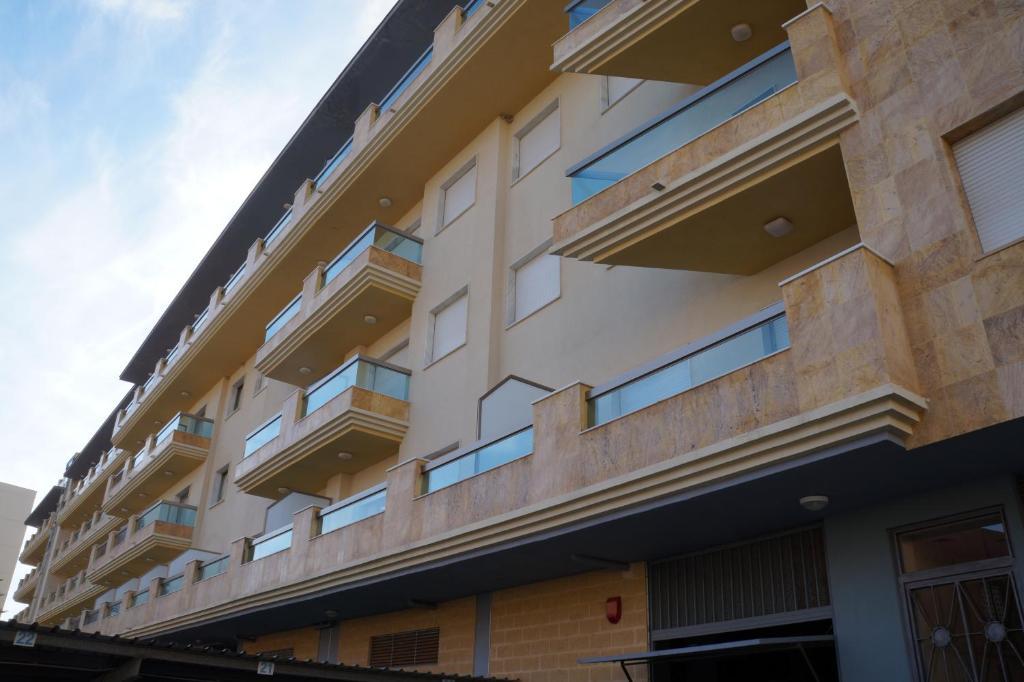 Un edificio con balcones a los lados. en Apartamentos Proamar, en Torre del Mar