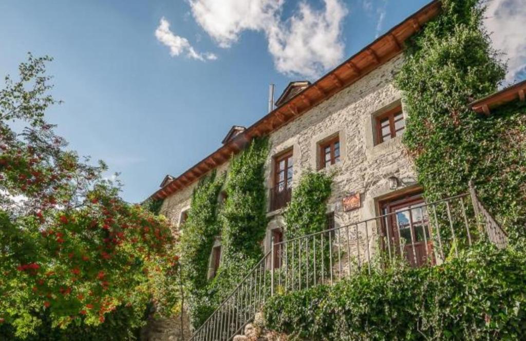 a building with ivy on the side of it at Hotel Rural LA CÁRCEL in Murias de Paredes