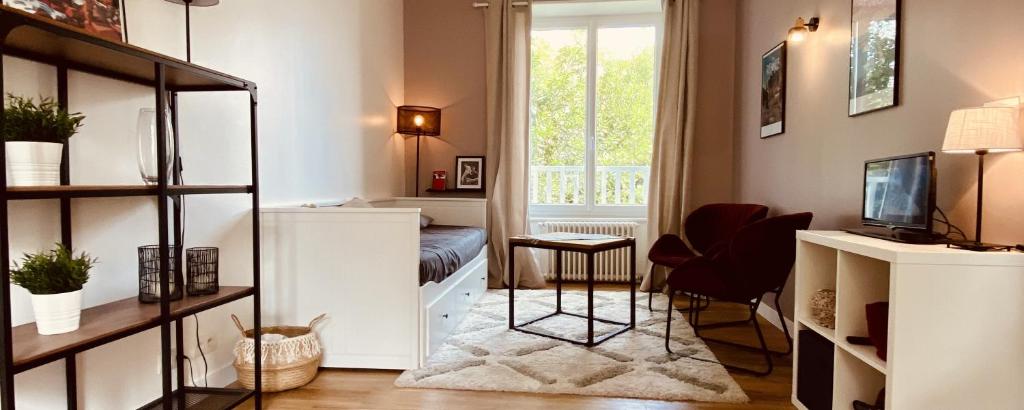 een kleine woonkamer met een televisie en een bureau bij CLINT HOUSE - Appartement "l'Île aux Moines" in Perros-Guirec