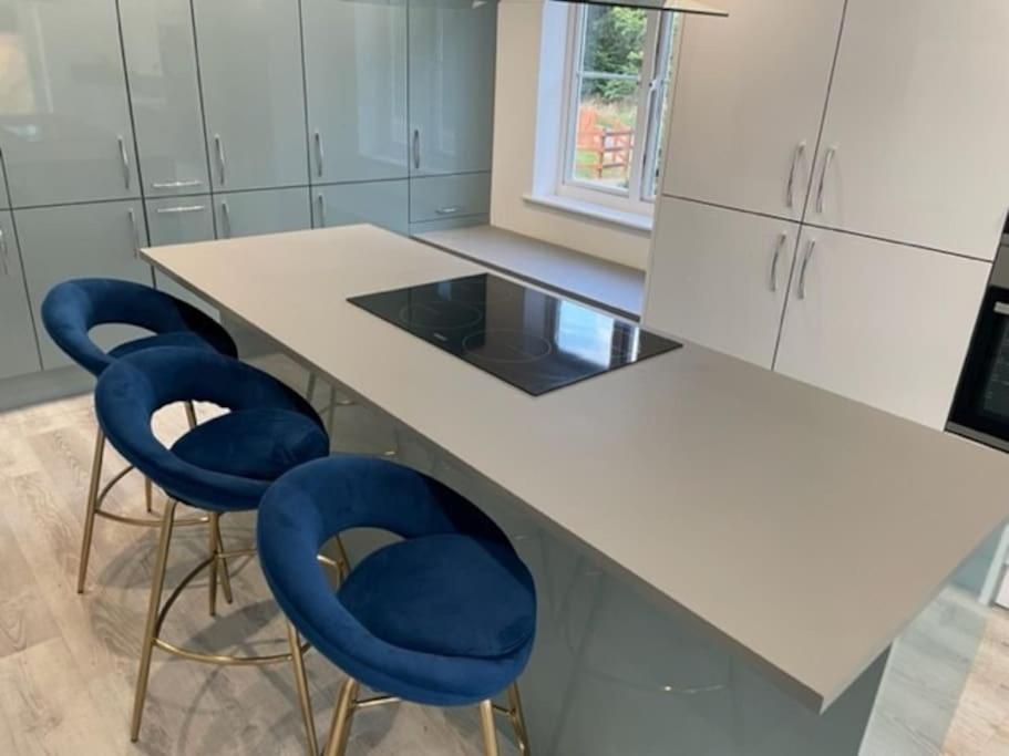a kitchen with two blue chairs and a counter at Large 5 Bedroom Family home with parking and WI-FI in Kettering