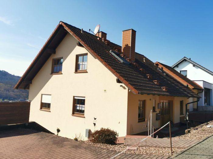 une maison blanche avec un toit marron dans l'établissement Ferienwohnung Fleckenstein, à Eichenbühl