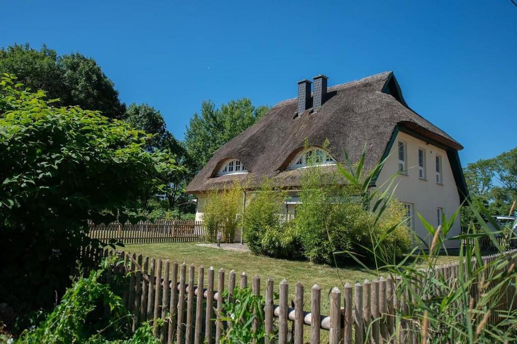 an old house with a thatched roof behind a fence at Naturferienhaus 1 in Mellnitz