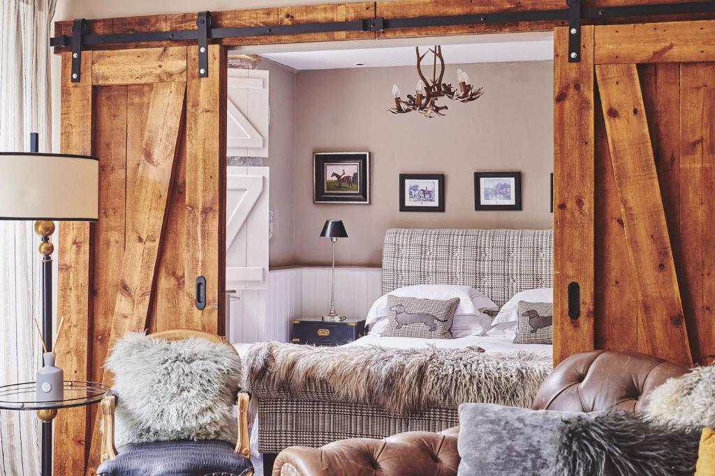 sypialnia z łóżkiem z dużymi drewnianymi drzwiami w obiekcie Mimosa Cottage w mieście Rhoose