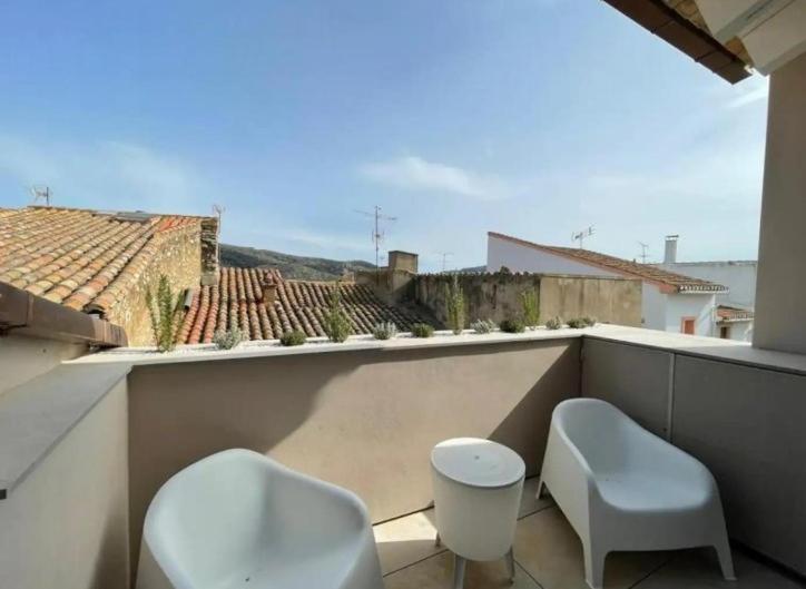 uma varanda com 2 cadeiras e 2 bancos em Casa Rural L'Alba em Catí
