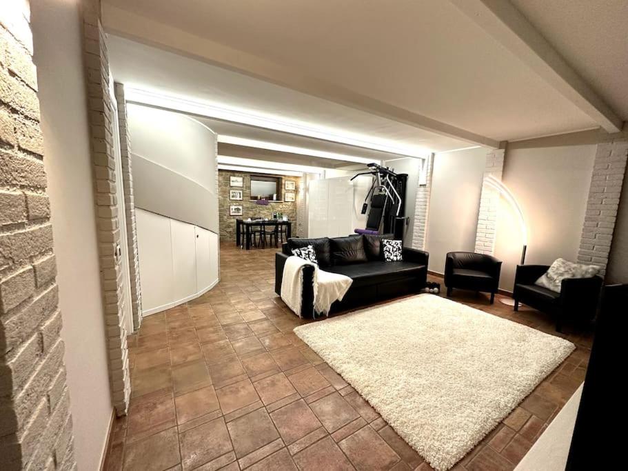 ein Wohnzimmer mit einem schwarzen Sofa und einem weißen Teppich in der Unterkunft Appartamento Ebhouse in Capiago Intimiano
