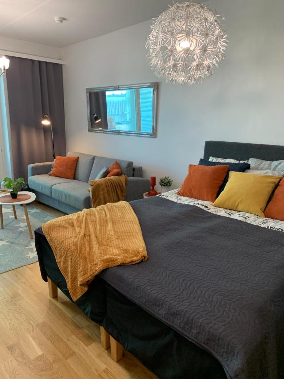 um quarto com uma cama e um sofá em StarHomes Studio Apartments em Oulu