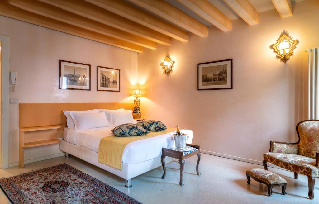 a bedroom with a bed and a chair and a table at Palazzo San Luca in Venice
