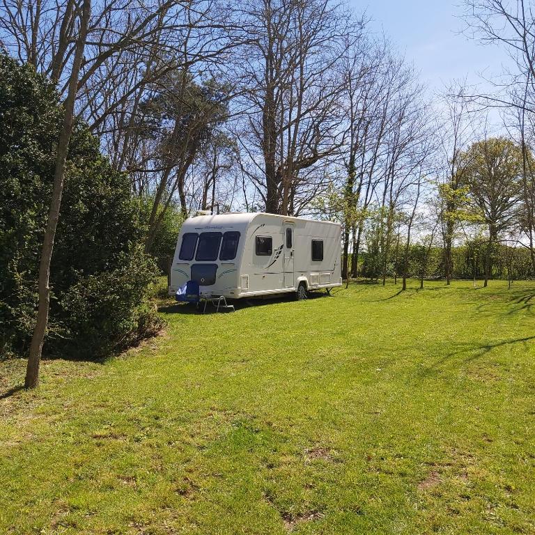 ein weißer Wohnwagen, der auf einem Grasfeld parkt in der Unterkunft Les Fontenelles in Saligny-sur-Roudon
