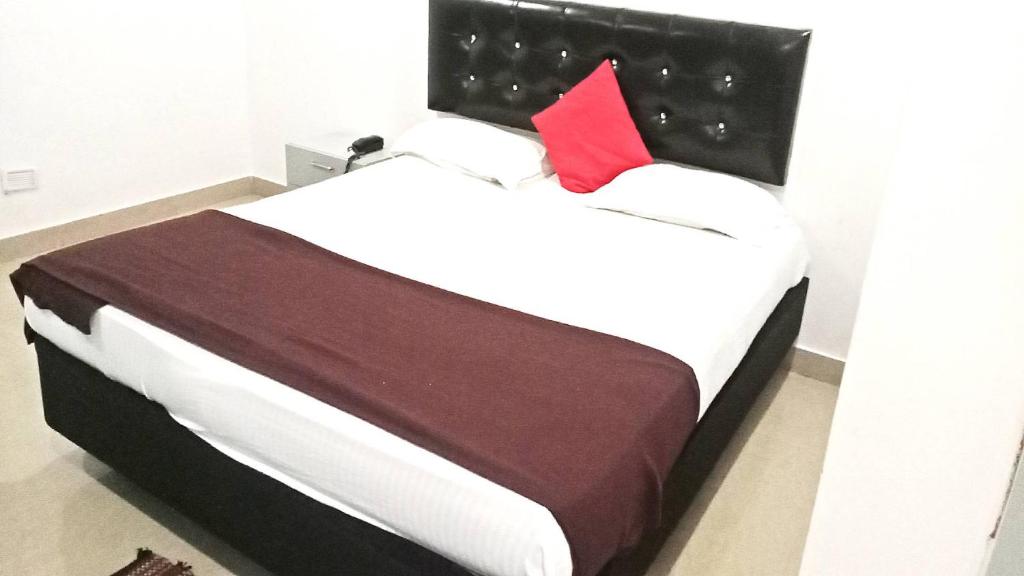1 dormitorio con cama grande y almohada roja en PPH Living Silver Villa 2, en Visakhapatnam