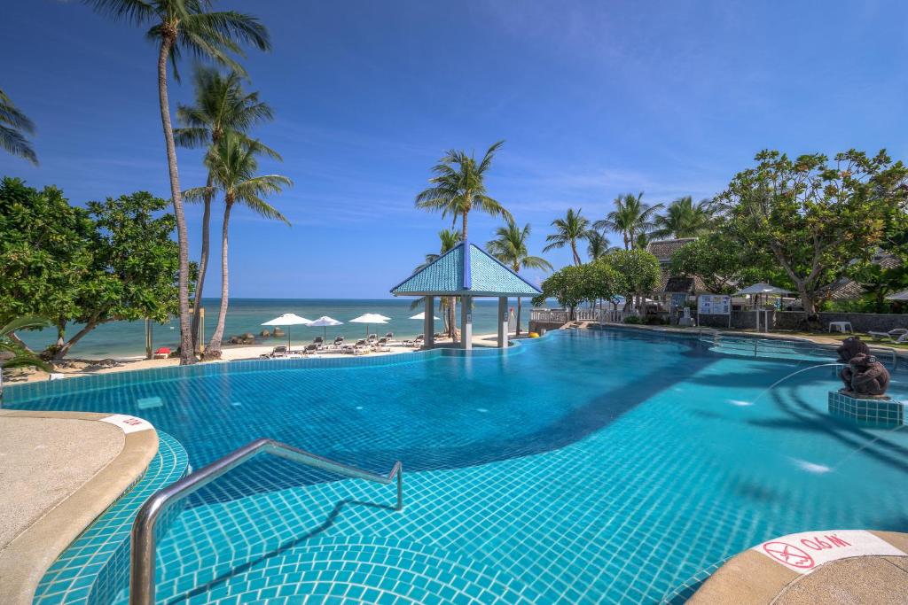 a large blue swimming pool next to the beach at Centara Villas Samui - SHA Plus in Lamai