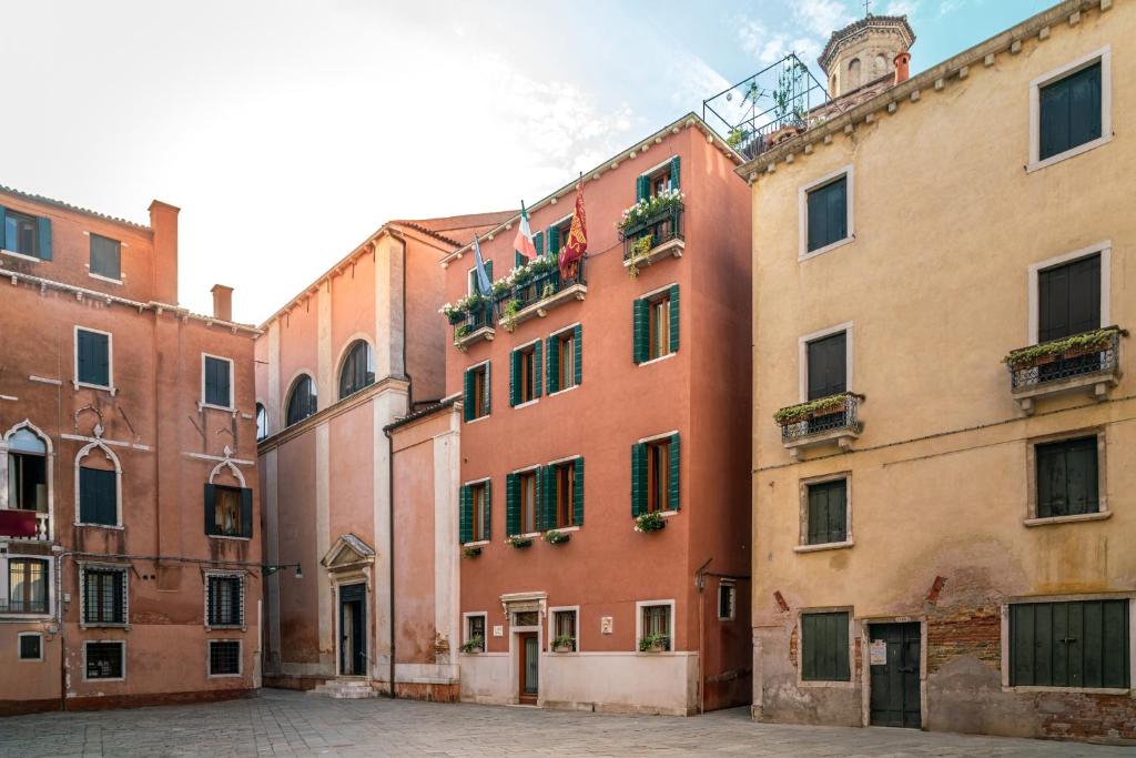 a group of buildings in a courtyard in a city at Palazzo San Luca in Venice