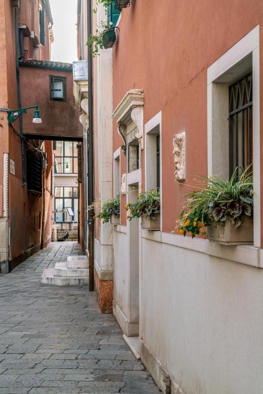 an alley with potted plants on the side of a building at Palazzo San Luca in Venice