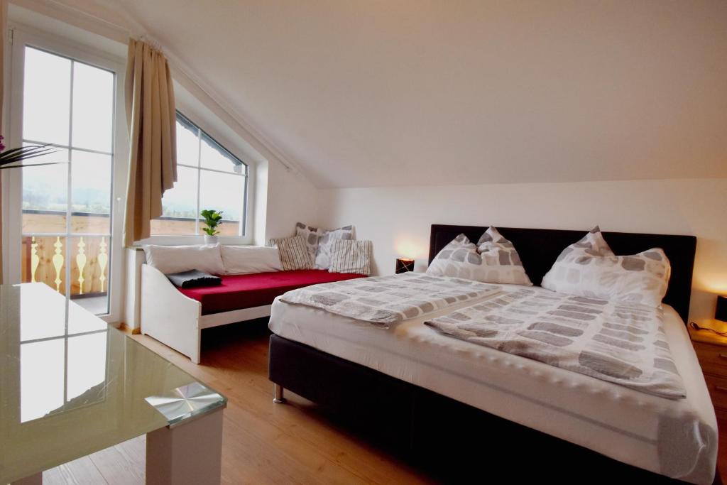 a bedroom with a large bed and a couch at Almblick Energiequelle in Bad Mitterndorf