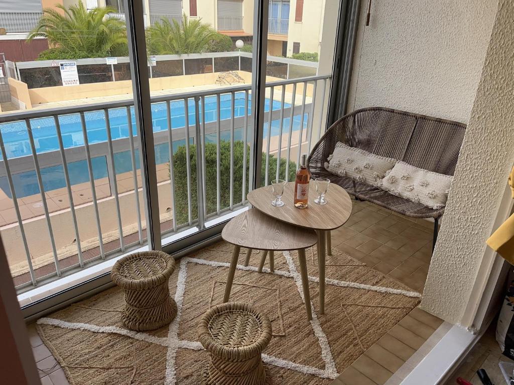 balcón con mesa, sillas y vistas a la piscina en Appartement T2 Gruissan port, rive gauche en Gruissan